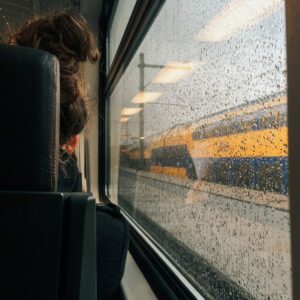 woman rides a train in England on a rainy day